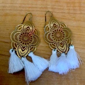 Cute long golden earrings with three white tassels on each of them